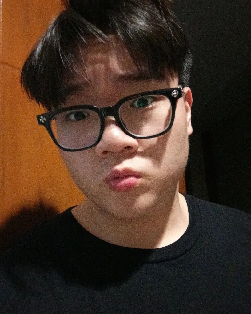 Portrait of Darrent Matthew wearing black-rimmed glasses and a black T-shirt